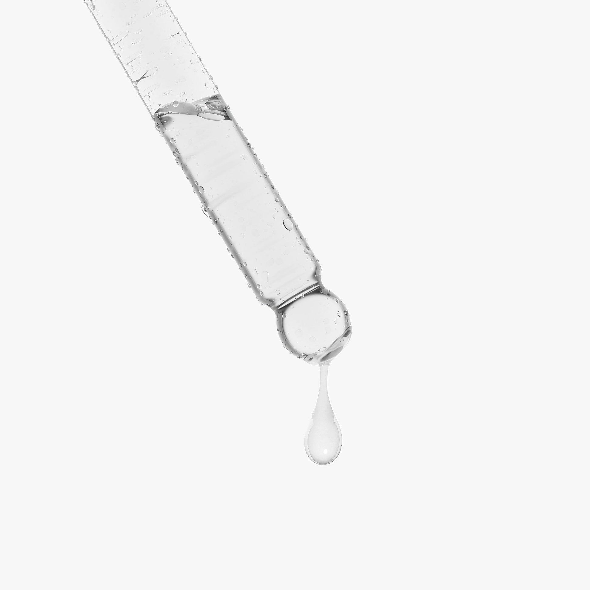 Syringe with clear liquid dripping on a white background